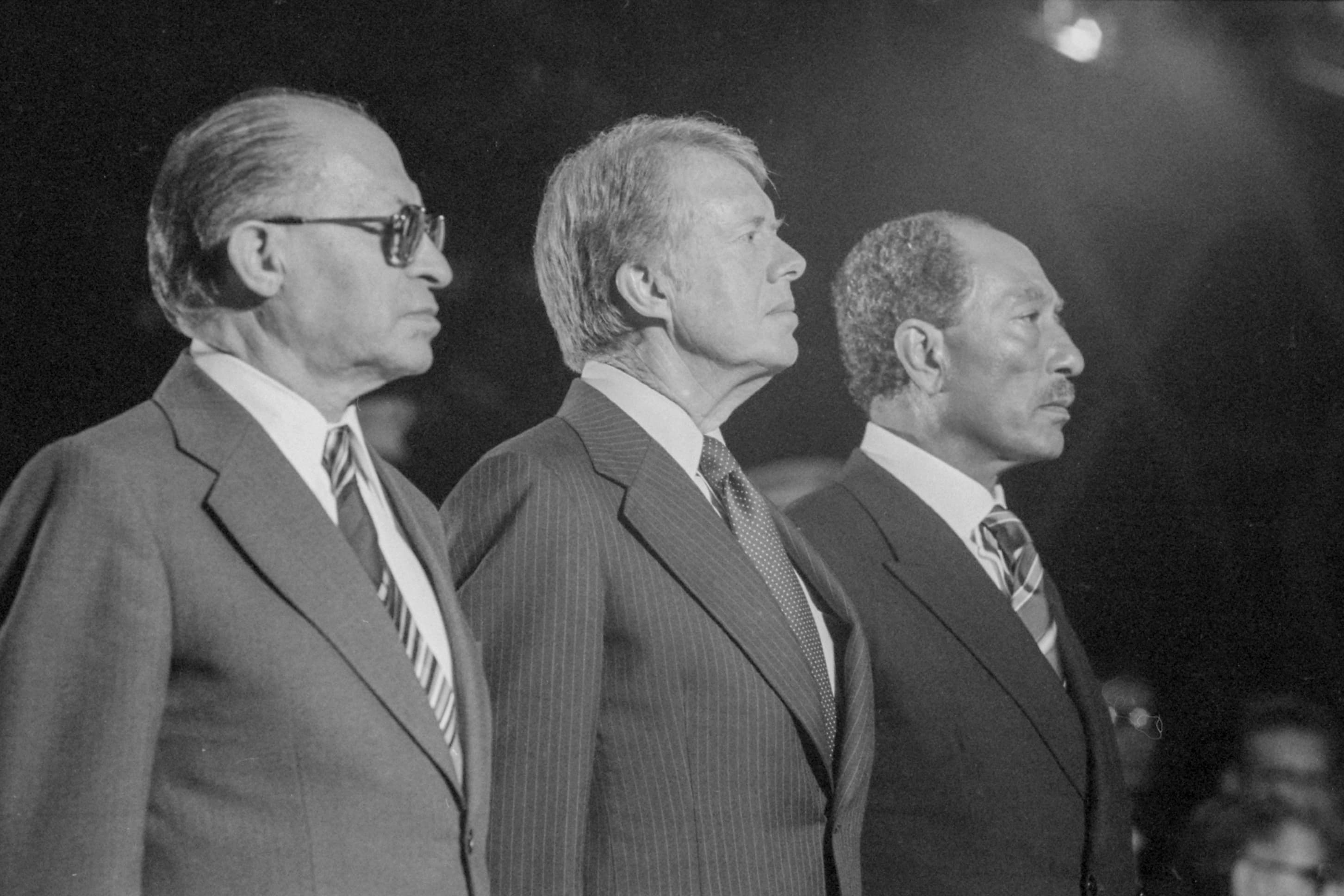 Anwar Sadat, Jimmy Carter and Menachem Begin seated together in conversation at Camp David in September 1978.