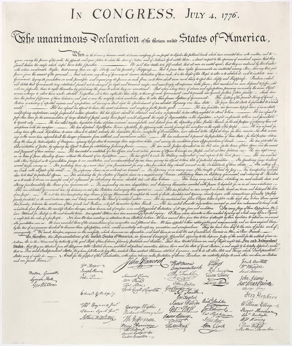 The engrossed Declaration of Independence, with the large signature of John Hancock beneath the text.