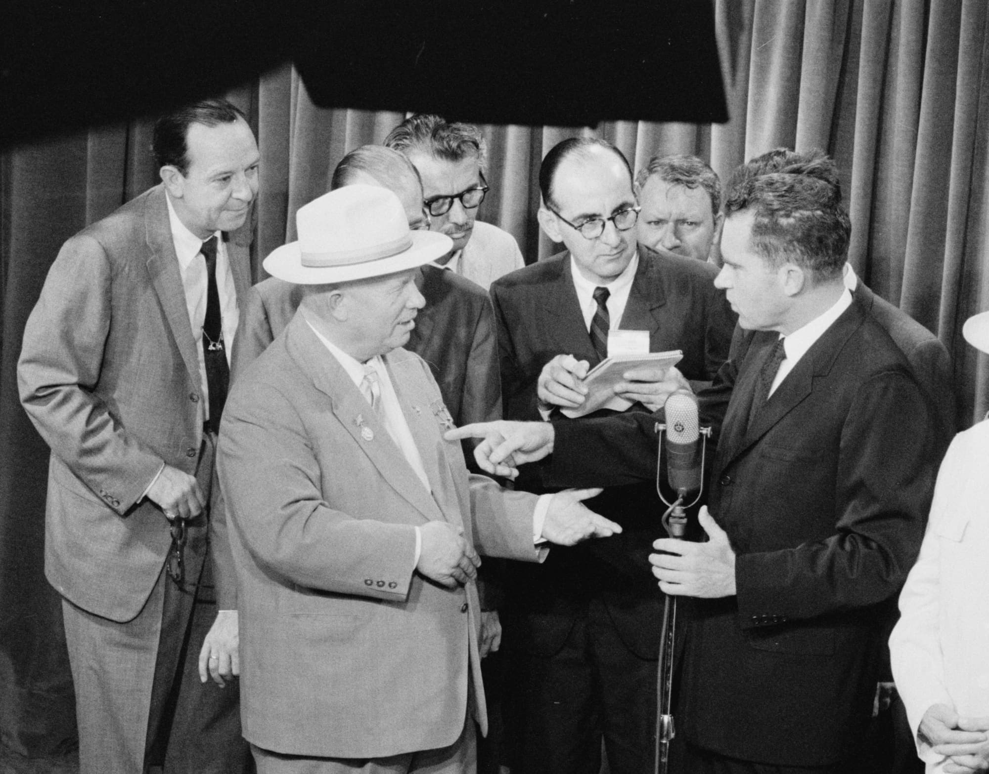 Nixon and Khrushchev facing each other across a railing in a model kitchen at the American National Exhibition in Moscow.